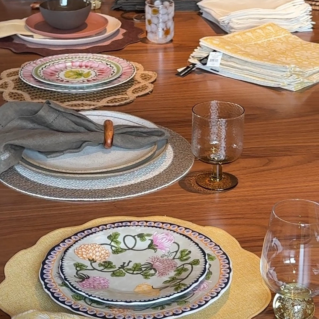 Mesa com jogos americanos de materiais diferentes: palha, tecido e jogo americano recortado