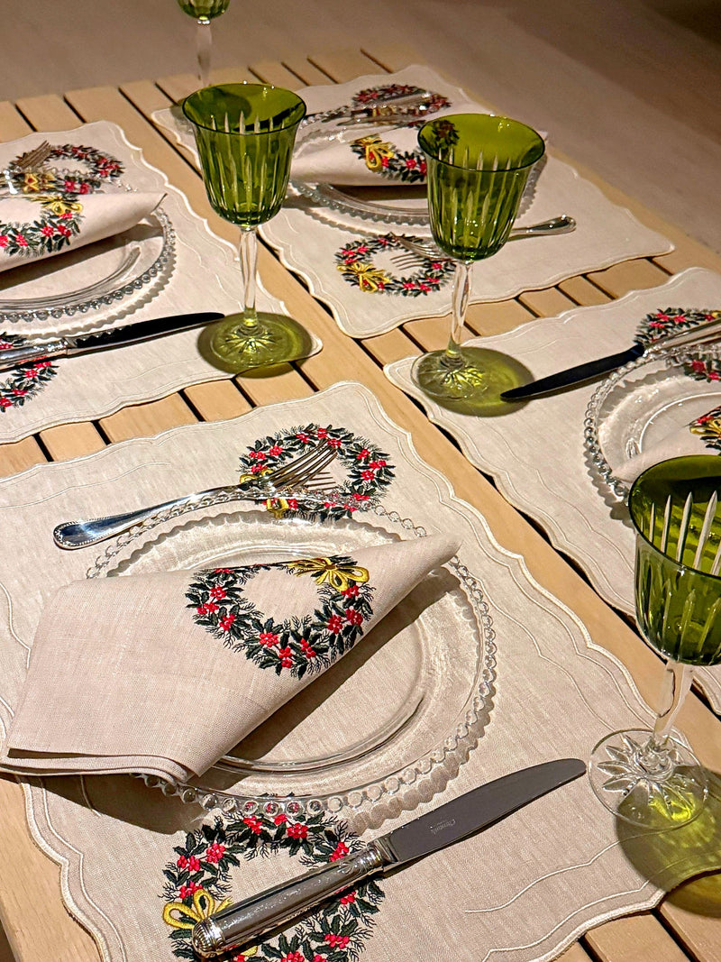 Mesa posta de Natal com jogo americano e guardanapo bordados com guirlanda e taças verdes