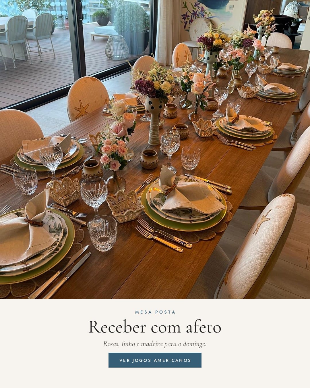 Mesa comprida de madeira posta com rosas, guardanapos de linho e jogos americanos